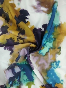 Détail du tissu d'une robe élégante avec imprimé aquarelle abstrait en jaune et bleu