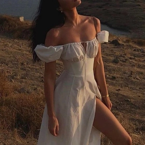 Detail of white puff sleeve off-shoulder dress with lace-up neckline and high slit