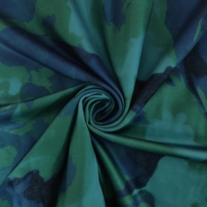 Macro shot of green camouflage fabric with smooth texture and silky sheen for women's dress