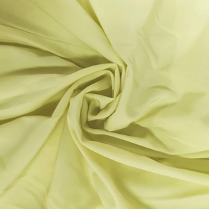 Detailed view of soft light yellow satin fabric texture with elegant draping effect