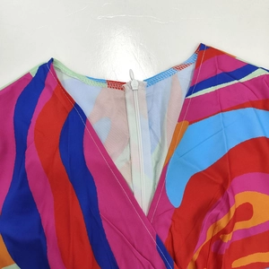 Detailed view of the V-neckline and concealed back zipper on a colorful printed dress