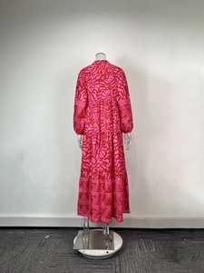Detail of red and pink bohemian floral print on a long-sleeved tiered maxi dress