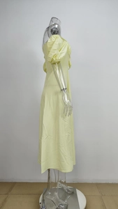 Detailed side view of light yellow off-the-shoulder dress with puff sleeves and slit