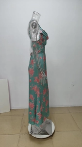 Side view of floral maxi dress with pink flower print on green fabric and slim fit design