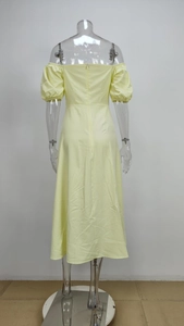 Detail view of the back of a light yellow off-shoulder dress with puff sleeves and invisible zipper