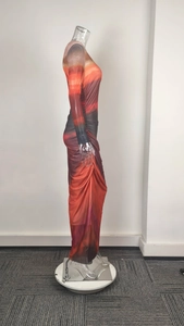 Detail of elegant slim fit maxi dress featuring orange gradient print and ruched side seams