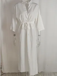 Detail of elegant white high-waist drawstring dress with V-neck and button cuffs
