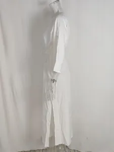 Detail of elegant white high-waist maxi dress featuring side slits and waist tie detail