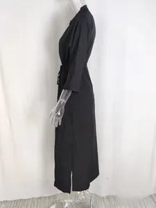 Detail view of black high-waisted dress featuring a side slit and drawstring waist cord