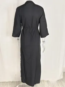 Detail view of the back of a solid color high waist maxi dress with tie waist and 3/4 sleeves