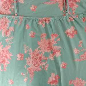 Detail of adjustable thin straps and smocked neckline on a floral mint dress
