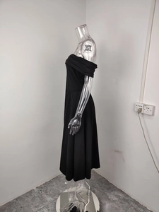 Dettaglio dell'elegante abito midi nero con spalle scoperte e gonna a trapezio a pieghe