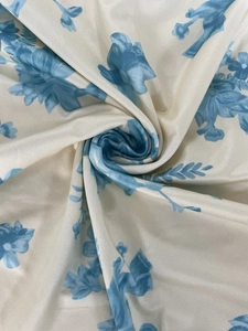 Detailed macro view of cream floral fabric with light blue patterns and silky texture