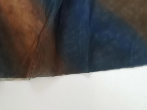 Macro view of breathable mesh fabric featuring brown and blue artistic gradient patterns