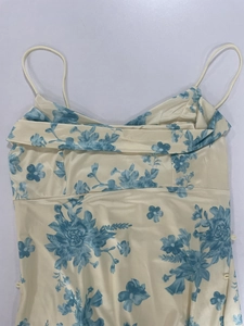 Detailed view of beige floral satin dress featuring adjustable spaghetti straps and ruffled neckline