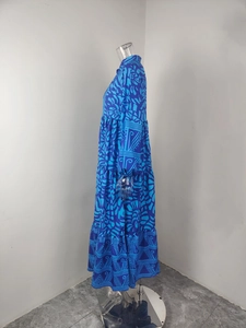 Detail view of the layered tiered hem and ethnic print on the blue V-neck maxi dress