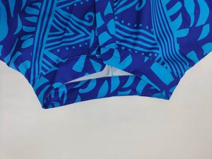 Detail view of double-stitched hem and blue geometric tribal print on V-neck maxi dress