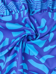 Detail of V-neck maxi dress featuring blue abstract geometric print and soft fabric texture