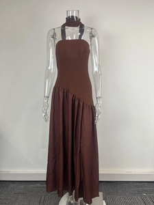 Gros plan d'une robe longue marron élégante avec fente latérale et design ajusté.