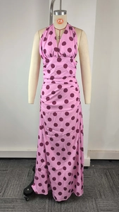 Detail of elegant pink V-neck halter dress featuring large burgundy polka dots and pleats