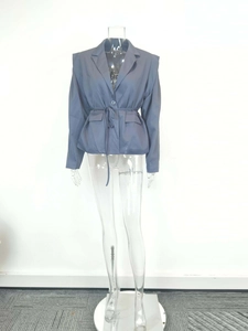 Détail d'un blazer gris bleu pour femme avec ceinture ajustable et poches à rabat