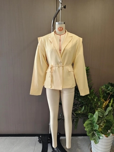 Détail de la veste blazer crème avec ceinture à la taille et poches à rabat sur mannequin