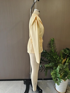 Vue latérale du blazer crème avec manches bouffantes et cordon de serrage à la taille