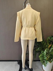 Vue arrière du blazer jaune montrant les épaulettes, la couture dos slim et la ceinture