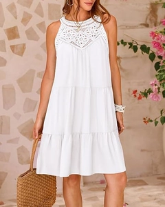 Dettaglio dello scollo in pizzo all'uncinetto bianco e della gonna a balze del vestito estivo