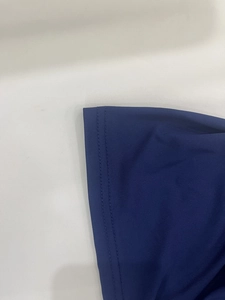 Close-up of navy blue dress showing fine knitted texture and double-needle hem stitching