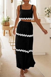 Dettaglio del crop top nero senza maniche e gonna lunga con bordo in pizzo ondulato