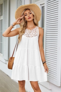 Dettaglio abito bianco smanicato con scollo all'americana, pizzo all'uncinetto e gonna a balze