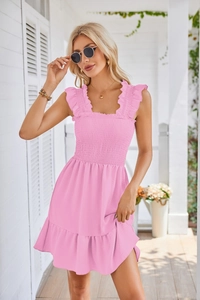 Detail of pink sleeveless mini dress featuring ruffled straps and ruched bodice detail