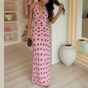 Elegant pink V-neck halter maxi dress with large brown polka dots in a dressing room