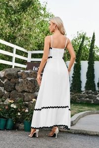 Detailed view of white midi dress with contrast black scalloped embroidery and wavy trim