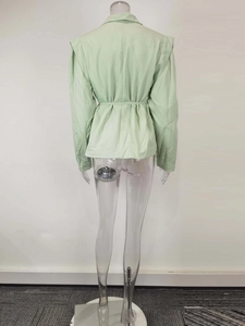Détail du blazer vert clair avec ceinture à la taille et design d'épaule structuré