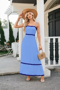 Detail of sky blue midi dress featuring navy wavy trim and textured summer fabric
