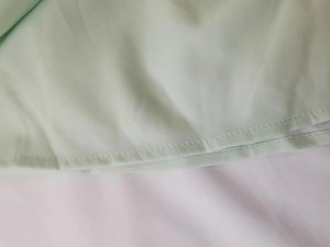 Gros plan sur les coutures de qualité d'une robe élégante vert clair de style français