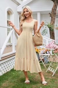 Detail of light yellow sleeveless dress with square neck pleats and ruffled hemline