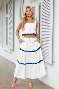Dettaglio del set due pezzi bianco con pizzo smerlato blu e gonna lunga a balze