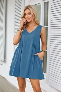 Detail of blue V-neck sleeveless dress with pleated waist and functional side pockets