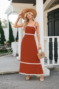 Detail of bohemian spaghetti strap dress with white wavy lace trim in burnt orange
