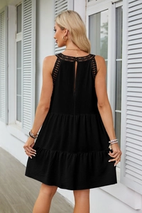 Dettaglio del mini abito nero a balze con pizzo all'uncinetto e scollo all'americana chic