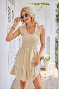 Detail of smocked elastic bodice and ruffle shoulder straps on beige sleeveless dress
