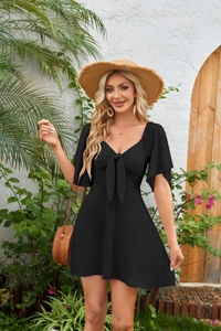 Detail of V-neck bow tie mini dress with ruffle sleeves on a vacation backdrop