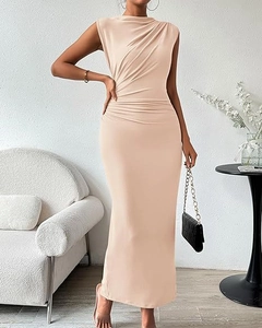 Détail du plissé latéral sur une robe longue beige sans manches moulante et élégante