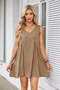 Detailed view of the V-neck babydoll dress with pleated waist and sleeveless design