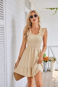 Detail of smocked chest design and ruffled shoulder straps on apricot sleeveless dress