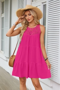 Dettaglio dell'abito fucsia con scollo in pizzo traforato e gonna a balze a strati