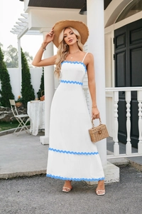 Detail view of the elegant scalloped blue trim on a white summer maxi dress